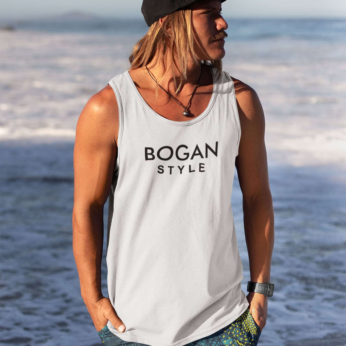 Surfer guy wears white tank top with Bogan Style printed on the front