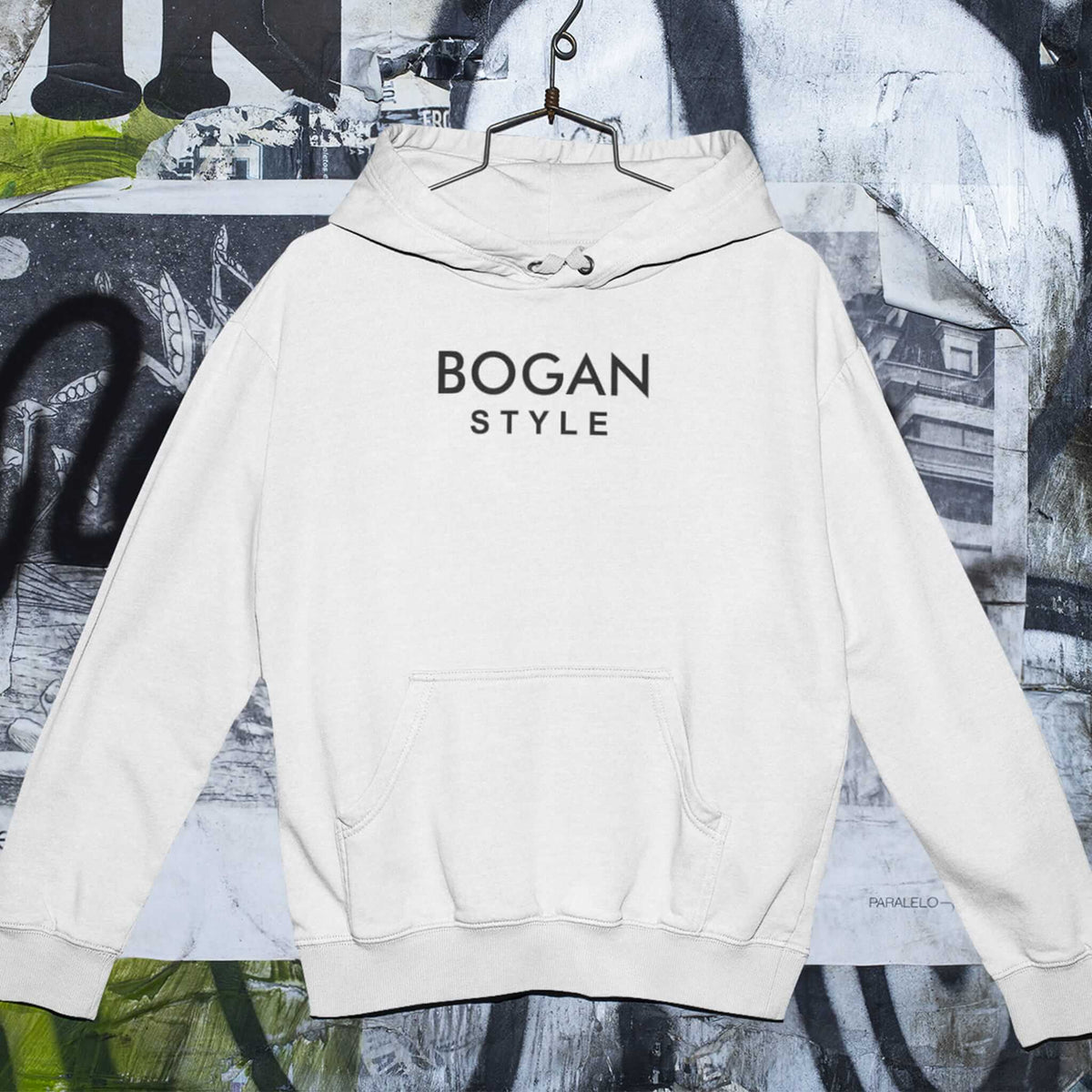 White hoodie with Bogan Style printed on the front on a graffiti background
