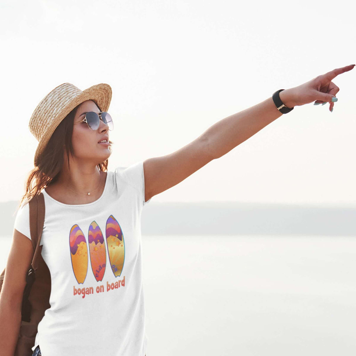 Woman wears white tee with graphic surf design.