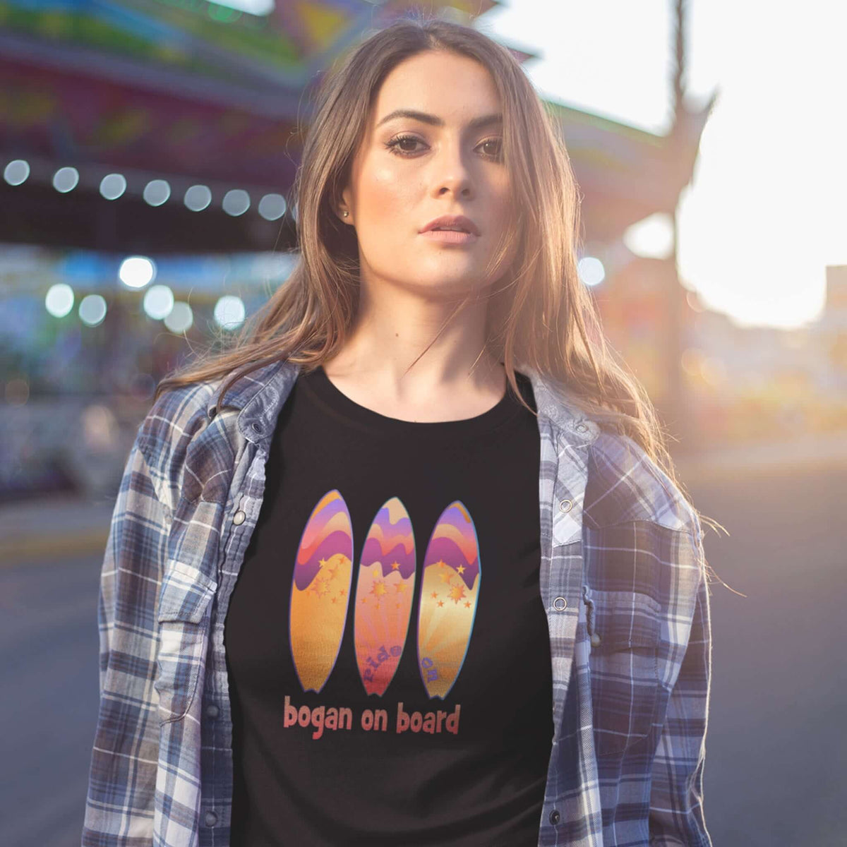 Woman wears black Bogan on Board tee with surf design. 